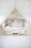 Modern cubby bed surrounded by storage in child's attic bedroom