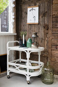 Serving trolley next to old door in rustic wooden wall