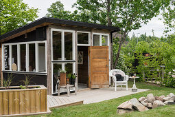 Rustikales Gartenhaus im Skandinavischen Stil mit Terrasse