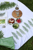 Snacks auf DIY-Picknickdecke mit Farnmotiv