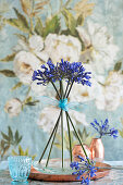 Standing arrangement of blue agapanthus on copper tray