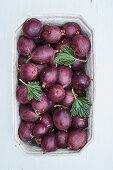 Red gooseberries in a cardboard bowl