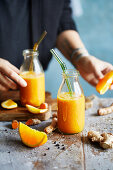 Orange and turmeric ginger drink in bottles
