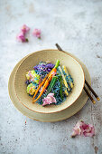 Blue rice with vegetables and edible flowers (vegan)