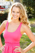 Junge blonde Frau in pinkfarbenem Top und Rock