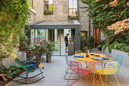 Colourful metal furniture in seating area on summery courtyard terrace