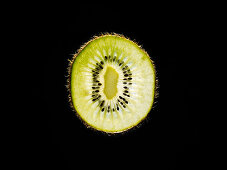 Backlit portrait of a kiwi slice