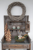Wicker wreath and wintry decorations on rustic potting table