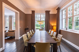 Elegant dining room in shades of brown with long wooden table and leather chairs