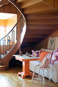 Retro seating area below wooden staircase