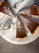 Chocolate tart with grated coconut, sliced