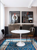 Classic table in dining area with industrial-style furniture and two framed ethnic headdresses on wall