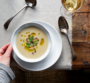 Cauliflower soup with garnish of fried cauliflower florets, olive oil and parsley