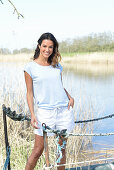 A young woman wearing a light-blue T-shirt and white shorts near river