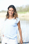 A young woman wearing a light-blue T-shirt and white shorts near river