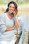 A young woman wearing a grey jumper near river