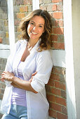 A young woman wearing a purple top, white shirt and jeans