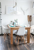 Wooden table and white shell chairs in summery dining room