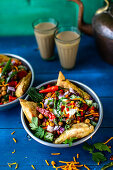 Chaat-Salat (scharfer Kichererbsensalat, Indien) mit Samosas und Erdnüssen