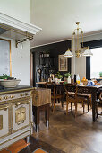 Antique, solid fuel cooker in open-plan kitchen and rustic wooden table in dining area