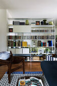 Leather armchair in living room with partition shelving screening bed