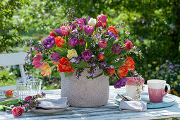 Colorful bouquet of tulips and purple gorse in a basket as table decoration