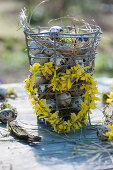 Heart made of gold bells on a wire basket with quail eggs