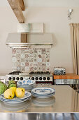 Quinces, artichokes and plates on stainless steel table in kitchen