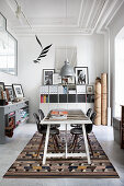 Conference table and classic chairs on kilim rug with filing cabinet in background