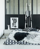 Schlafbereich mit schwarz-weißer Bettwäsche im Loft