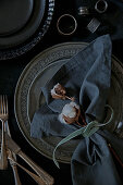 Linen napkin, cotton bolls and velvet ribbon on silver plate