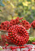 Kranz aus Zieräpfeln und Korb mit Chrysanthemen