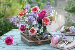 Small bouquets with roses, lilacs and hornwort as table decorations