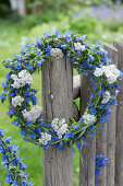 Blue and white wreath of blueweed and yarrow on the fence
