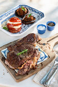 Grilled steak on a ceramic and wood board on marble table