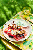 Grilled seitan skewers on watermelon