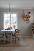 Round table and chairs with turned legs and spokes in rustic kitchen-dining room