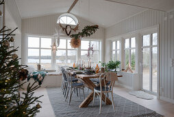 Set table in Scandinavian-style conservatory decorated for Christmas