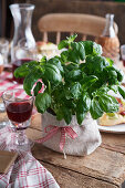 Basil in a jute sack on a wooden table