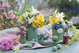 Small Easter bouquets made from primroses, daffodils, forget-me-nots, horned violets and daisies in tin cans, Easter bunnies and Easter eggs