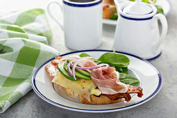 Breakfast sandwich with prosciutto, avocado, eggs and bacon