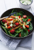 Vegan Schupfnudeln with spinach and strawberry salad and herb dressing