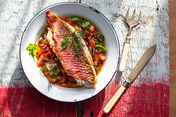 Fried red mullet fillet on a tomato and onion salad with fresh herbs