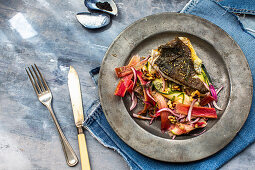 Fried fish fillet on a vegetable salad with rhubarb