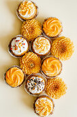 Cupcakes with vanilla cream cheese frosting decorated with sugar sprinkles in autumn style