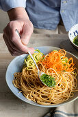 Pesto über Vollkornspaghetti mit Gemüsespirelli geben