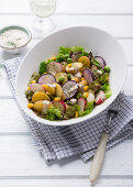 Potato salad with radishes, lettuce and vegan yogurt dressing