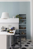 Barstools at counter in open-plan kitchen with honeycomb floor tiles