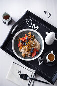 Knusper-Porridge mit Schokolade, Früchten und Ahornsirup auf Tablett