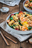 Mediterranean pasta salad with rocket, tomatoes and grilled prawns